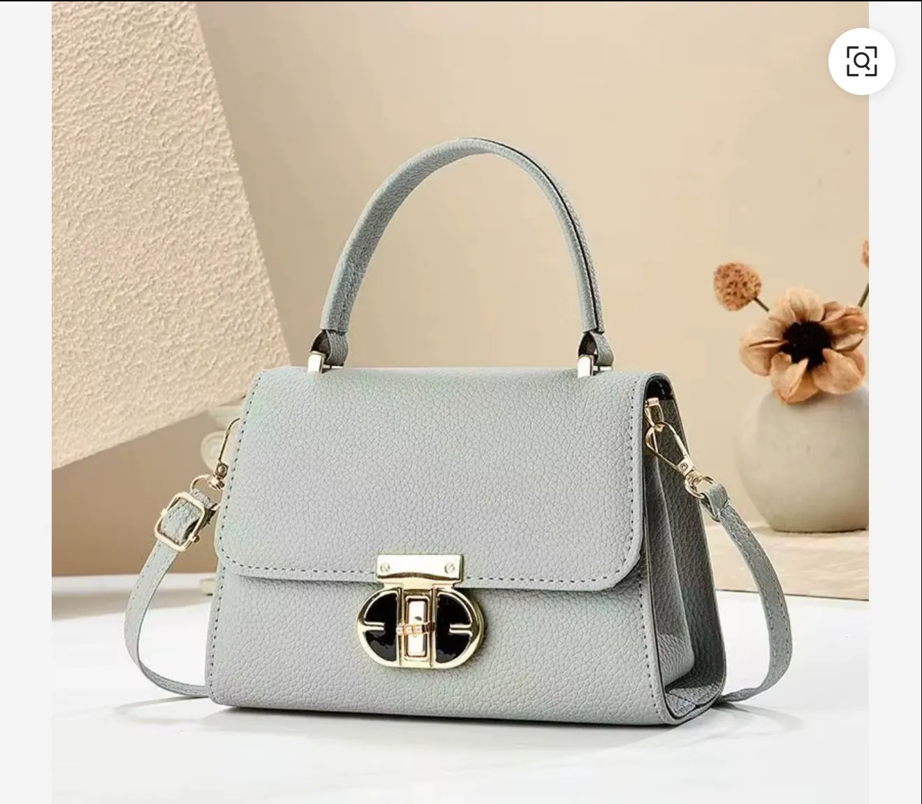 Light grey women's handbag styled in a refined editorial setting